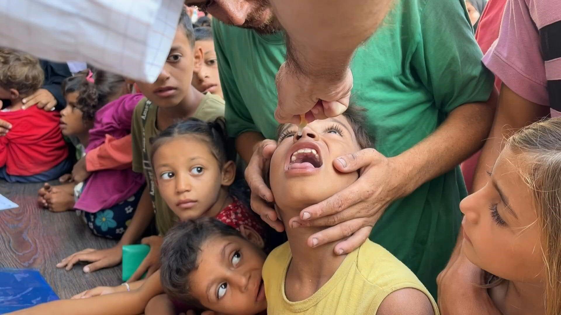 Healthcare workers administer polio vaccine drops to Gazan children