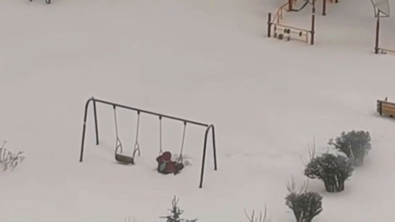 Spielplatz nach Sturm eingeschneit: Stures Kind lässt sich nicht vom Schaukeln abhalten