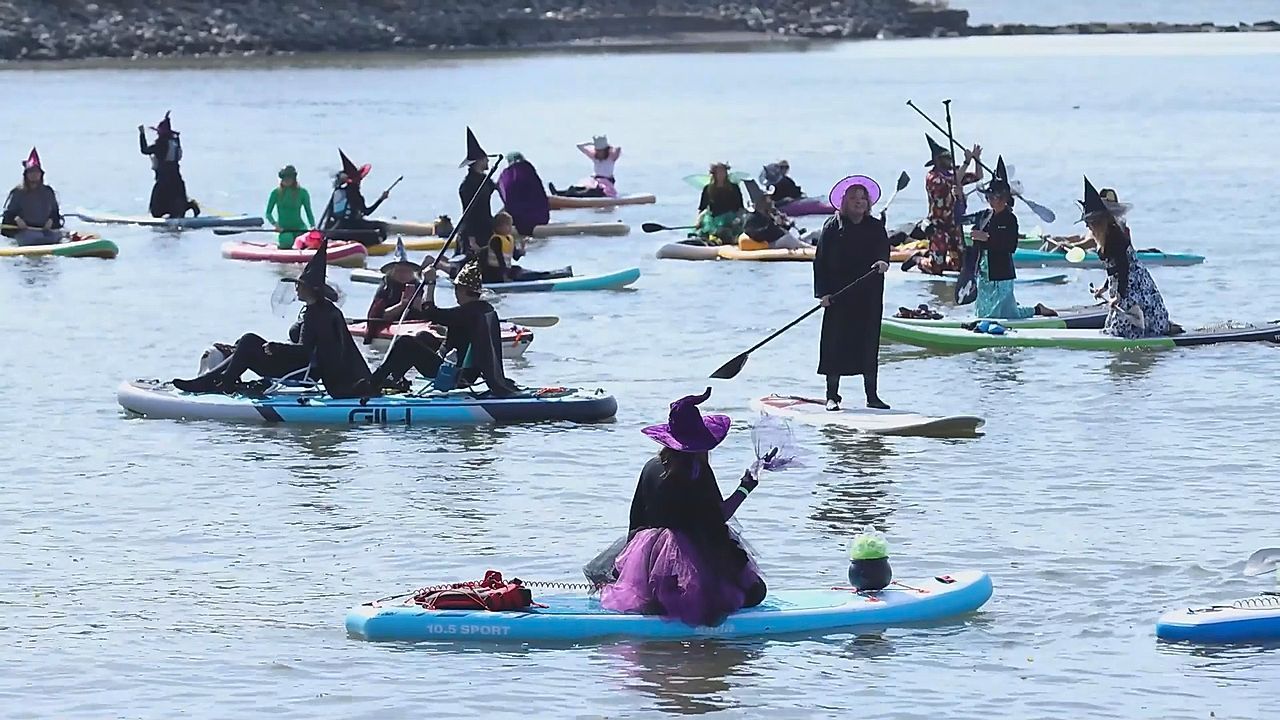 Witches paddleboard along the Hudson River for Halloween festival