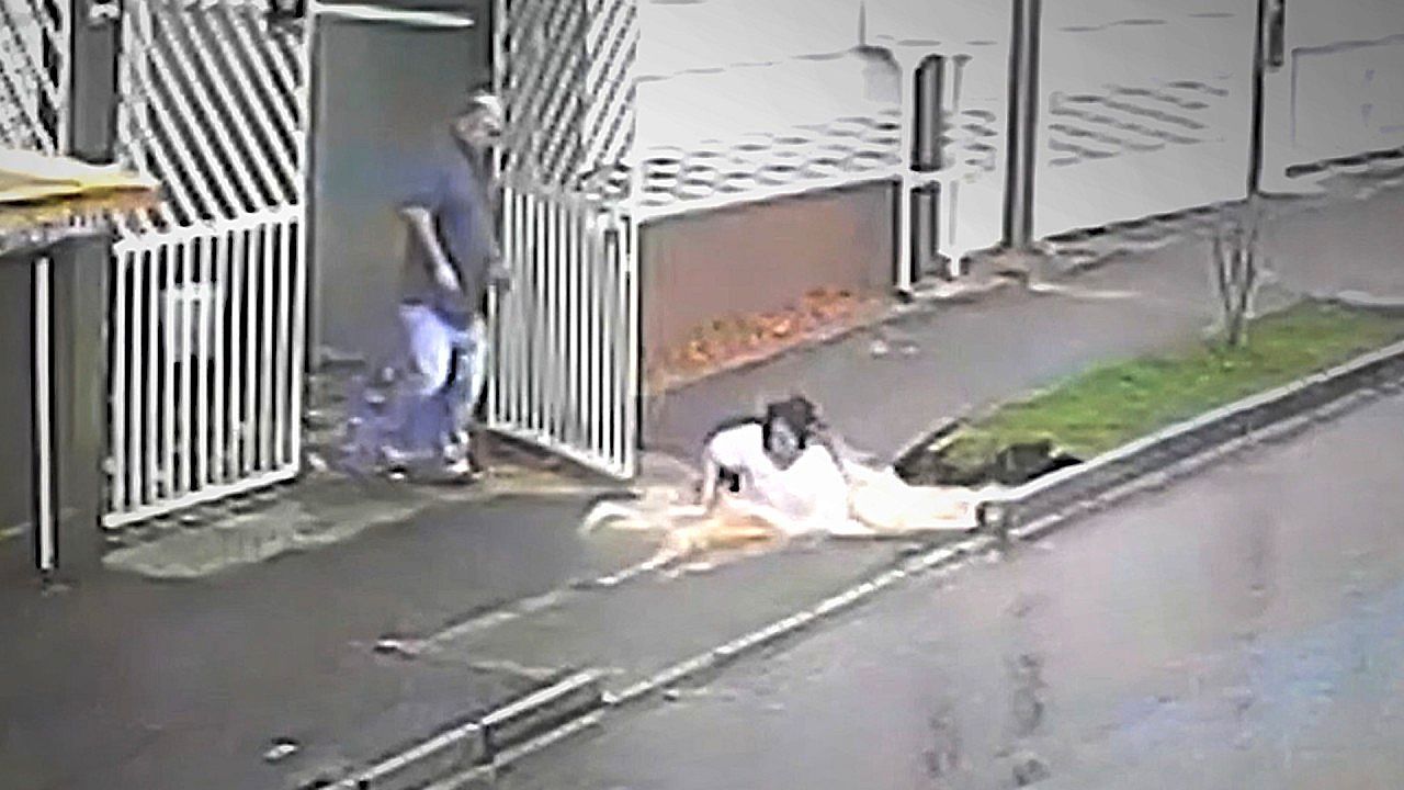 Video: Rain-filled sinkhole opens up under woman's feet on the sidewalk