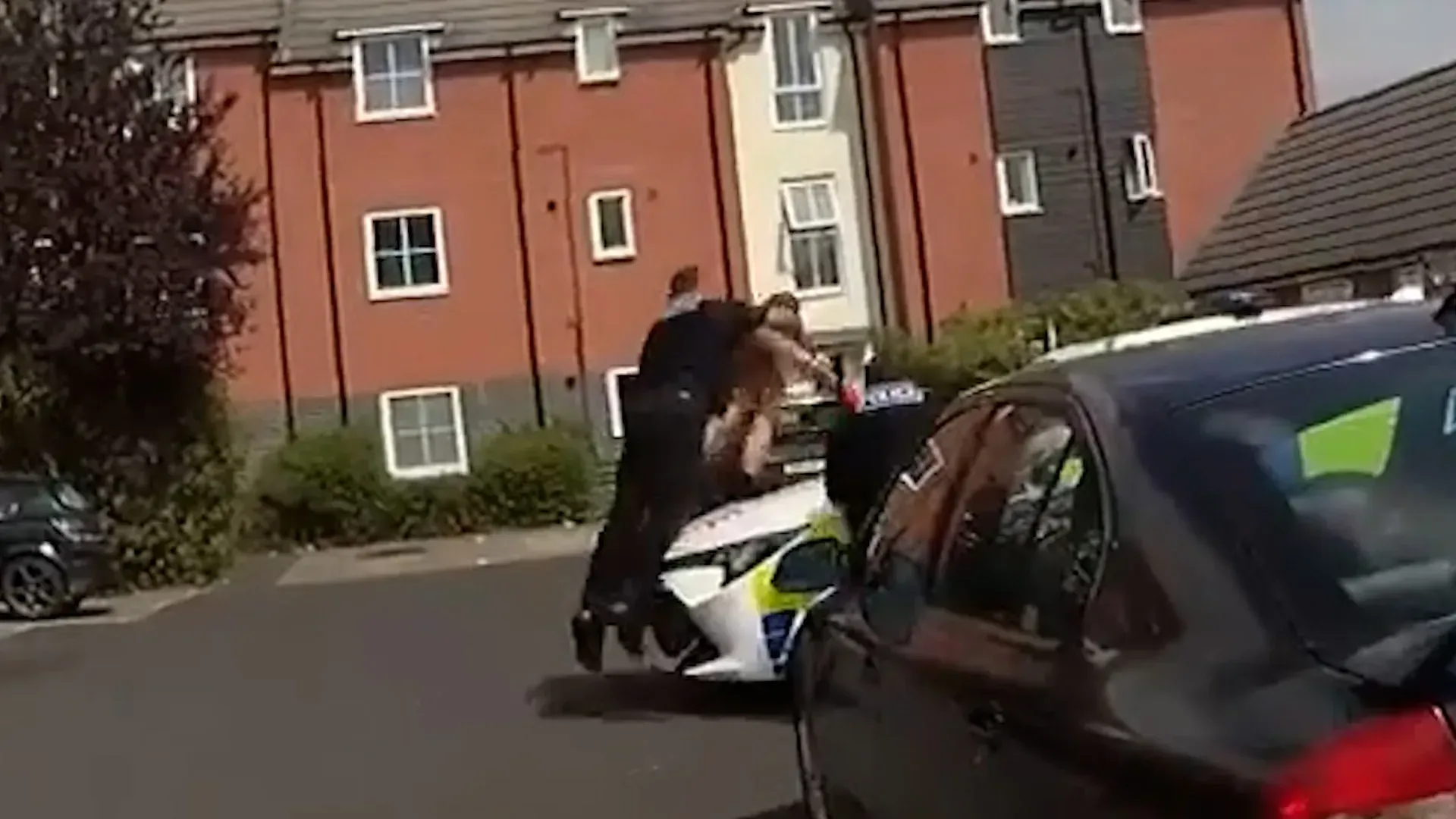 Video: Verdächtiger mit nacktem Oberkörper von der Polizei mit einem Rugby-Tackle überwältigt, als er versuchte, über einen Streifenwagen zu fliehen