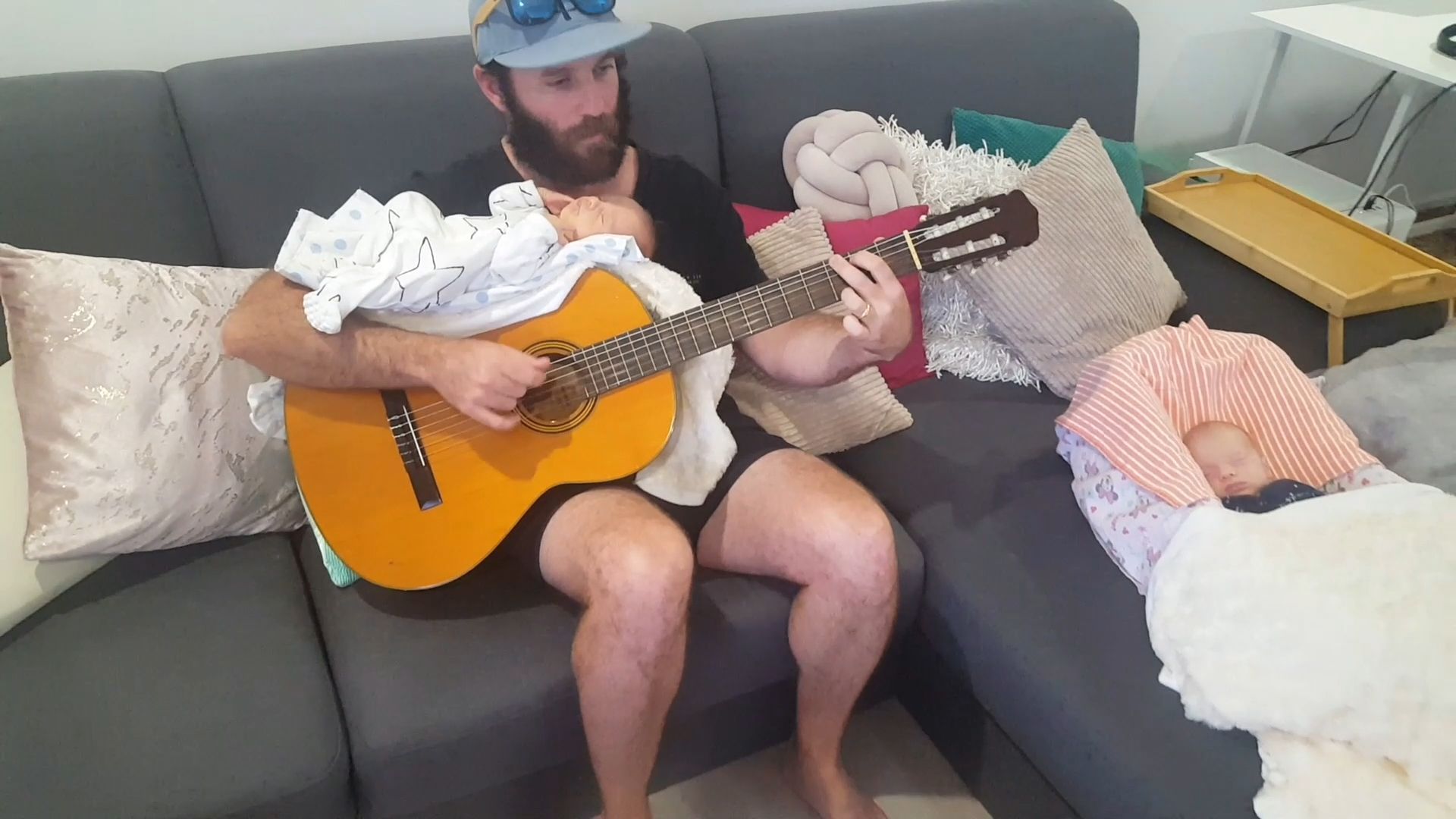 Vater legt Zwillinge auf Gitarre und singt sie in den Schlaf